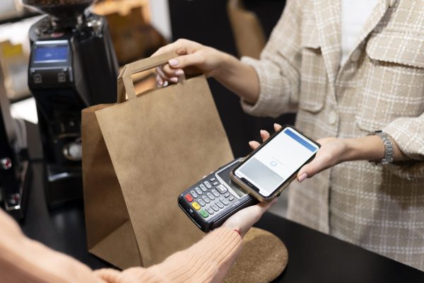 pessoa fazendo o pagamento das compras com o celular