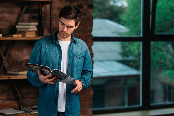 Homem lendo a revista institucional - Freepik