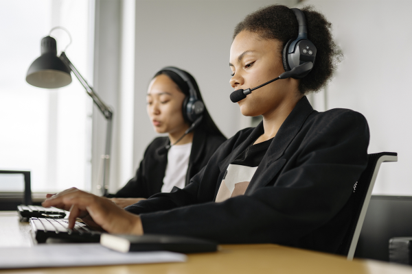 duas mulheres trabalham a comunicação de uma empresa em seus computadores