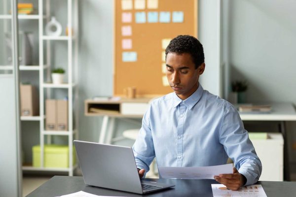 Jovem homem negro trabalhando no notebook para a imprensa - Freepik