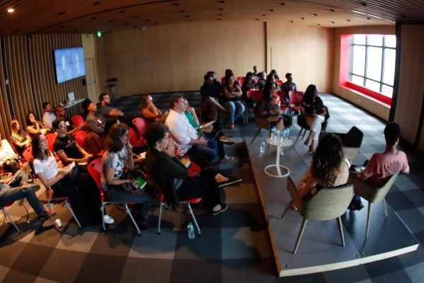 foto do evento fake news desinformacao e diversidade público a esquerda e debatedores a direita com telao