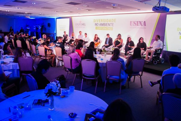 evento tamem é conteudo. mesa de debate da Usina da Comunicacao sobre Diversidade. Público e debatedores estão em um palco.