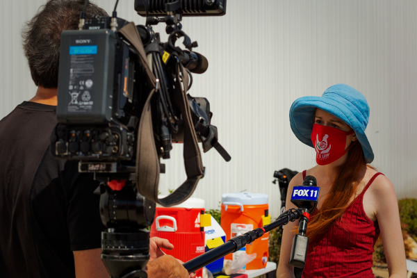 profissional do jornalismo entrevista personagem respeitando o distanciamento social recomendado por conta da pandemia do coronavírus.