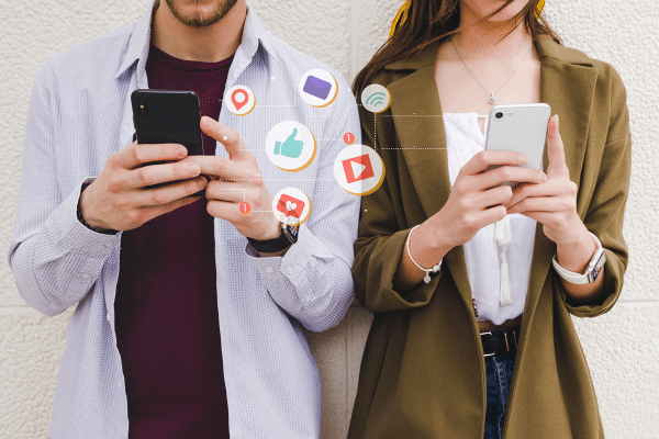 Homem e mulher usando plataformas de rede social no celular - Foto: Magnific