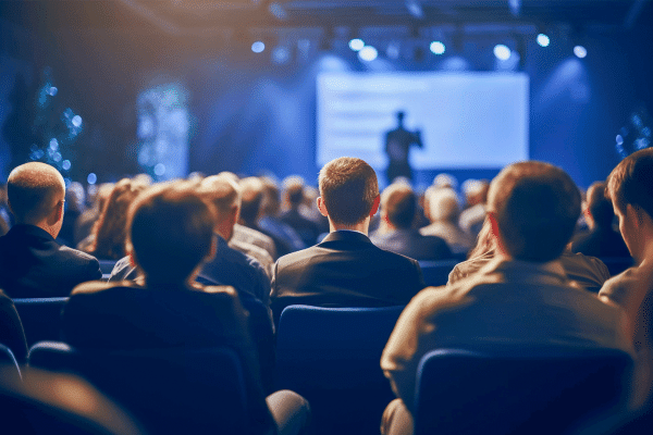 Pessoas sentadas no evento assistindo a palestra